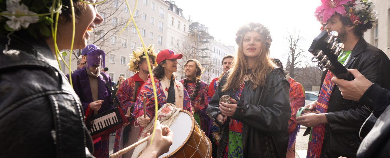 Musikant*innen mit Blumengränzen auf einer Straße in Wien. 